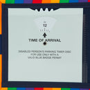 A close up of the timer clock inside the Rainbow Blue Badge Wallet. The acetate window stops before the top of the clock allowing the dial to be turned to adjust displayed Time Of Arrival. An arrow points to the dial numbers. Text below reads TIME OF ARRIVAL. Under that is written Disabled person's parking timer disc for use only with a valid blue badge permit.