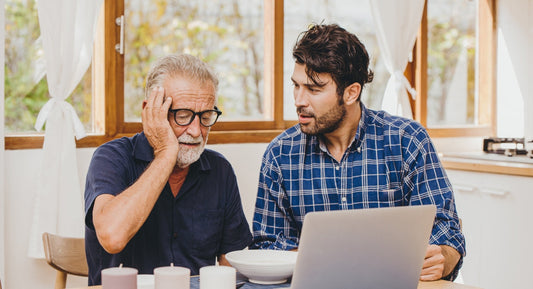 young man trying to help an elder with the laptop