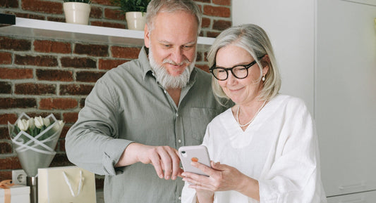 Older man and woman looking at a phone together.