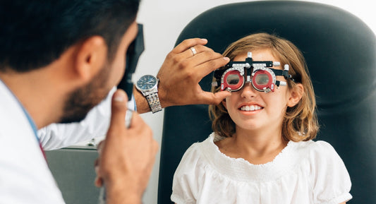 Young girl wearing a trial frame during an eye exam.