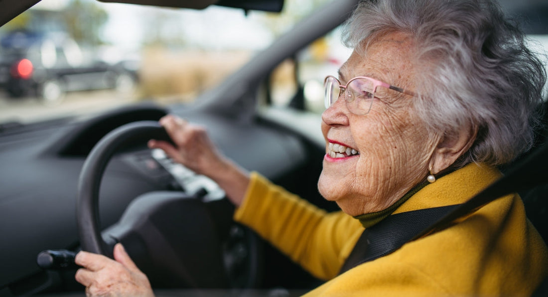 smiling elderly woman driving a car.