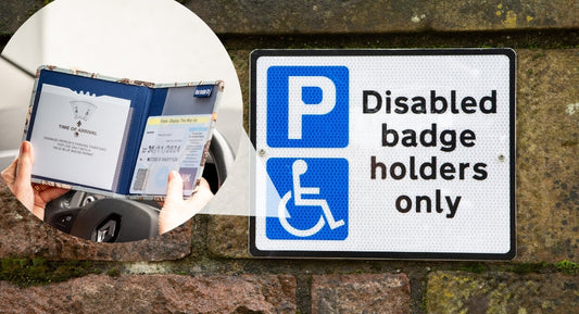 Hand holding a disabled parking permit next to a restricted parking sign.
