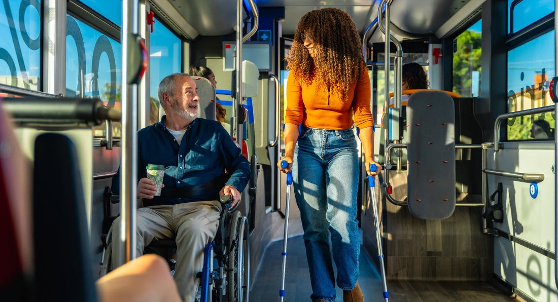 Man in a wheelchair and a woman using crutches inside a bus.