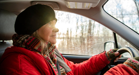woman inside car driving wearing winter gear