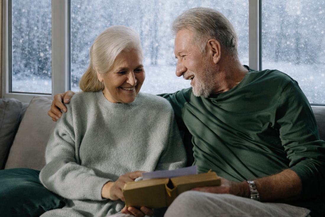 couple reading a book at home with snow falling from outside the window