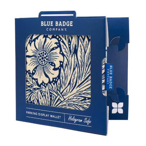 Disabled Blue Badge Wallet in William Morris Marigold Indigo fabric is packed in blue badge company recyclable packaging. The Blue Badge Co label sits outside the card box through a side gap. Packaging reads "Blue Badge Company" at the top and "Parking Display Wallet, Hologram Safe" at the bottom.