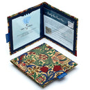 Two Disabled Blue Badge Wallets in William Morris Golden Lily fabric are pictured. One stands open showing clock display on left behind plastic window, with room to adjust time dial. On the right is a card insert showing place for permit with a hologram safe design. Second, closed wallet lays in front of the open wallet to display fabric. The William Morris Golden Lily fabric is a classic botanical print depicting leaves and flowers in red, green, gold and blue, on a rich cream background.