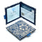 Two Disabled Blue Badge Wallets in William Morris Marigold Indigo fabric are pictured. One stands open showing clock display on left behind plastic window, with room to adjust time dial. On the right is a card insert showing place for permit with a hologram safe design. Second, closed wallet lays in front of the open wallet to display fabric. The William Morris Marigold Indigo fabric is a botanical flower and leaf pattern with cream flowers on a navy blue background.