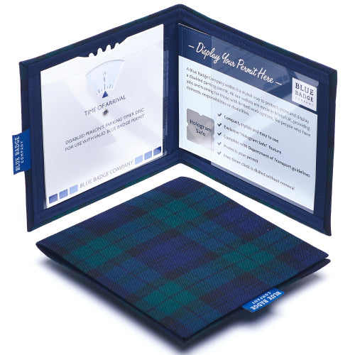 Two Disabled Blue Badge Wallets in Blackwatch Tartan fabric are pictured. One stands open showing clock display on left behind plastic window, with room to adjust time dial. On the right is a card insert showing place for permit with a hologram safe design. Second, closed wallet lays in front of the open wallet to display fabric. The Blackwatch Tartan fabric is a classic tartan print in black, green and blue.