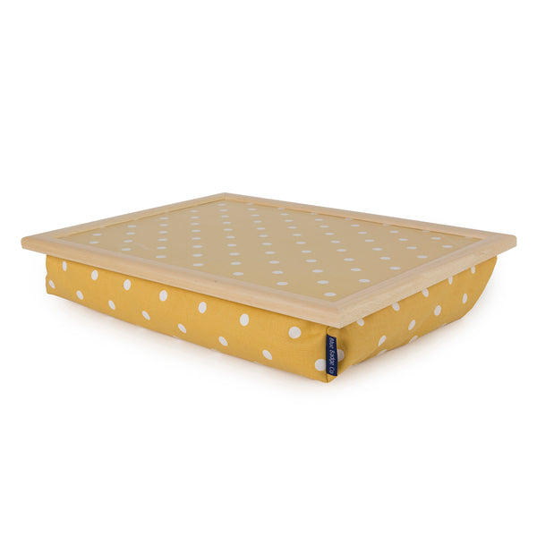 Bean Bag Cushion Lap Tray in Canary Yellow Spotty fabric. The fabric is a deep yellow with white spots dotted in a regular symmetrical pattern, an inch apart. The lap tray has a smooth a see through laminated top, showing the patterned fabric, and a wooden beading edge.