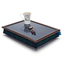 The bean bag lap tray in Blackwatch Tartan is pictured against a white background. On the tray stand a pair of glasses and a floral cup with tea.