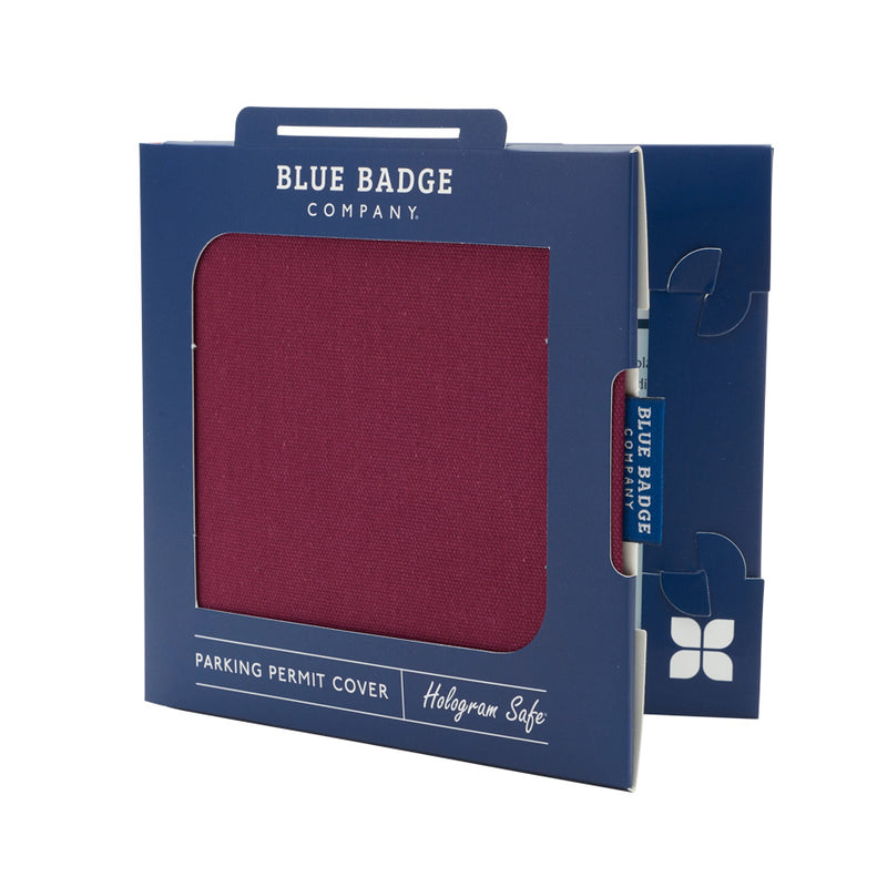 Disabled Blue Badge Wallet in Burgundy Panama fabric is packed in blue badge company recyclable packaging. The Blue Badge Co label sits outside the card box through a side gap. Packaging reads "Blue Badge Company" at the top and "Parking Display Wallet, Hologram Safe" at the bottom.