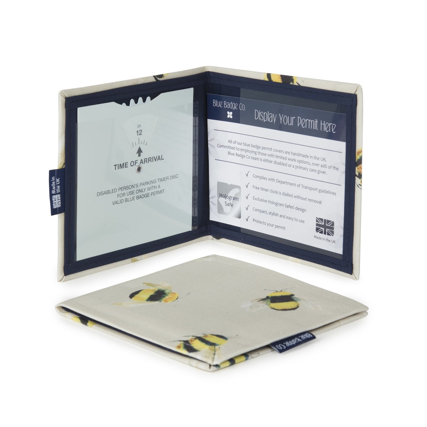 Two Disabled Blue Badge Wallets in Busy Bees fabric are pictured. One stands open showing clock display on left behind plastic window, with room to adjust time dial. On the right is a card insert showing place for permit and a hologram safe design. Second, closed wallet lays in front of the open wallet to display fabric. The Busy Bees fabric has a pattern of black and yellow bumble bees with delicate white wings, on a cream background.