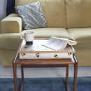 The Busy Bees Bean bag lap tray is on a small table in front of a light yellow velvet sofa. On the tray rests an open book and a coffee cup.
