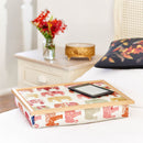 Bean bag lap tray in Nelly Elephant print on a white bed with an eReader on top. 