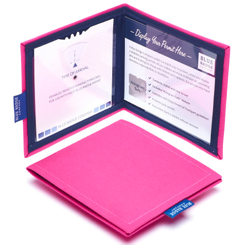 Two Disabled Blue Badge Wallets in Pink Panama fabric are pictured. One stands open showing clock display on left behind plastic window, with room to adjust time dial. On the right is a card insert showing place for permit and a hologram safe design. Second, closed wallet lays in front of the open wallet to display fabric. The Pink Panama fabric  is a bold block colour.