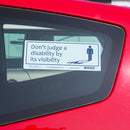 Disabled Car Sticker Rectangle  - Don't judge a disability by it's visibility is stuck on the inside of a red car
