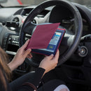 The Blue Badge Wallet is held slightly open, in two hands, against a steering wheel.