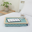 The lap tray in Aqua Marine Spotty is pictured on top of a bed dressed with white bed linen. The tray holds a white mug of coffee, an electronic tablet and a pen. A plant stands on a side table next to the bed.