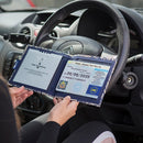 Open Disabled Blue Badge Wallet held in two hands against a steering wheel. The adjustable timer display clock is on the left. On the right is a Devon County Council Disabled Parking Permit with hologram. The acetate window doesn't cover the hologram.