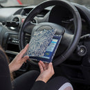 The Blue Badge Wallet is held slightly open, in two hands, against a steering wheel.