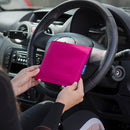 Blue Badge Wallet in Pink Panama is held in two hands against the steering wheel of a vehicle