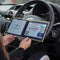 Open Disabled Blue Badge Wallet held in two hands against a steering wheel. The adjustable timer display clock is on the left. On the right is a Devon County Council Disabled Parking Permit with hologram. The acetate window doesn't cover the hologram.