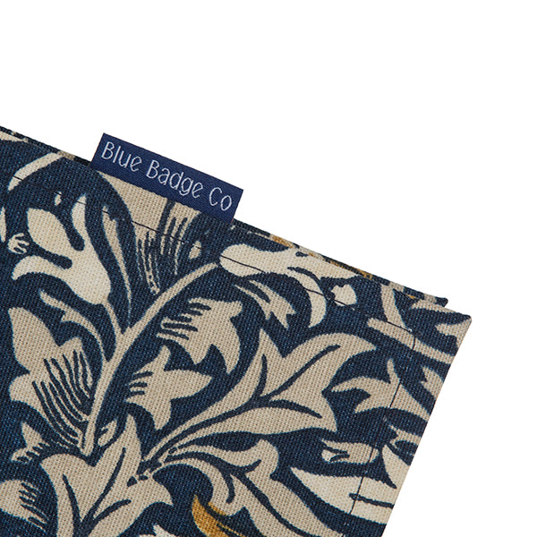 A close up of one corner of the Blue Badge Wallet in William Morris Snakeshead fabric, with the Blue Badge Co label showing.